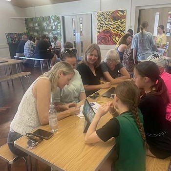 Group around a table with papers and ipads