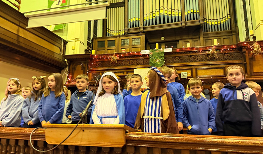 Two children wearing mary and joseph clothes in the christmas concert