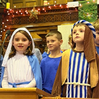 Close shot of two children wearing mary and joseph clothes in the christmas concert
