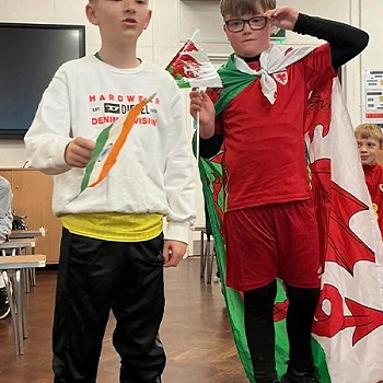 Dau plentyn yn gafael mewn fflag o Cymru a India
