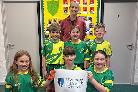 tim peldroed gyda aelod o dannedd davies