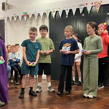 Grwp o blant yn actio fel rhan o gwasanaeth blwyddyn 3 a 4