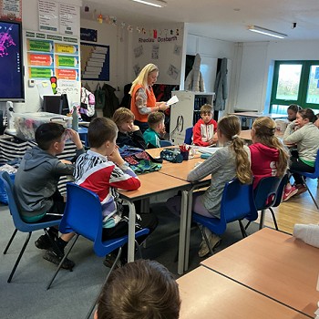 dosbarth o fyfyrwyr yn eistedd wrth eu desgiau