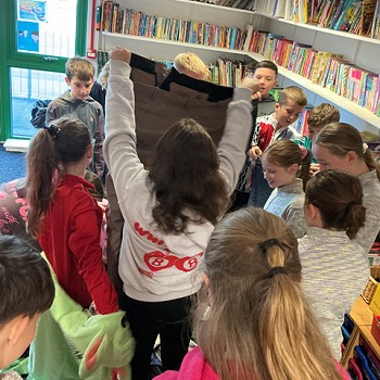 myfyrwyr yn dal darnau o ffabrig i fyny