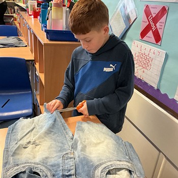 myfyriwr yn torri coes pâr o jîns