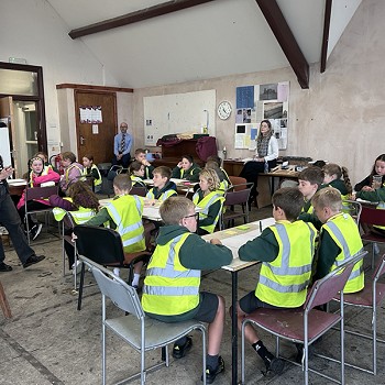 class of students sitting down in hi vis