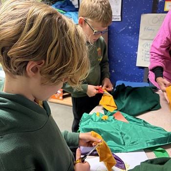 plant yn torri ffabrig gydag siswrn