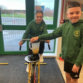 Girl on a bike and a boy holding the smoothie lid