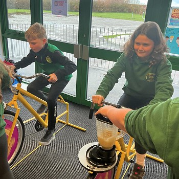 two pupils on bikes creating energy to make a smoothie
