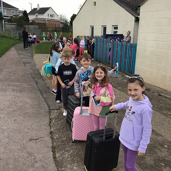 myfyrwyr y tu allan gyda'u cês dillad