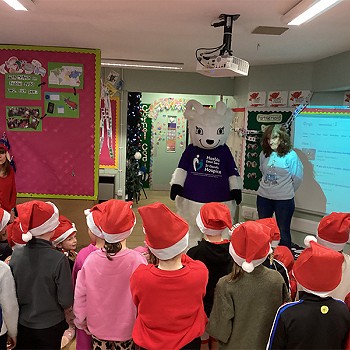 Plant yn gwisgo hetiau Siôn Corn gyda ymweliad gan fasgot Hosbis Dewi Sant