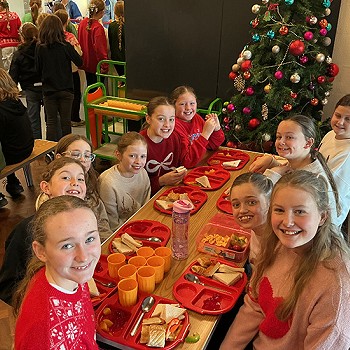 A group of girls around a table enjoying Christmas tea