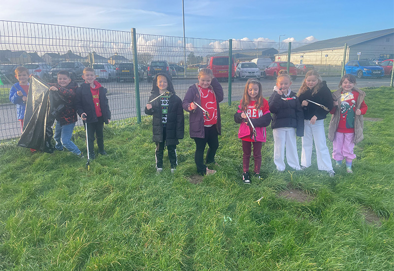 Plant blwyddyn 3 yn mwynhau codi sbwriel o gwmpas yr ysgol