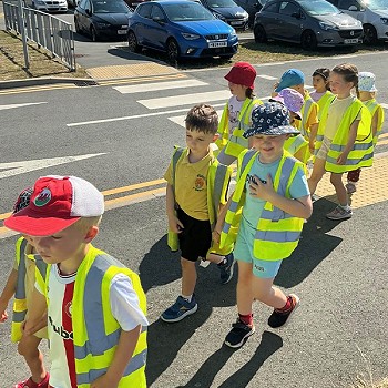 Golwg agos o plant yn cerdded gyda'i gilydd ar y palmant wrth ymyl ffordd
