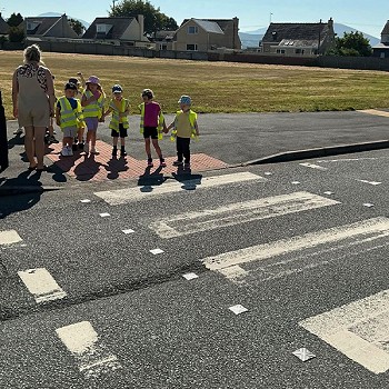 Plant yn aros i croesi ffordd