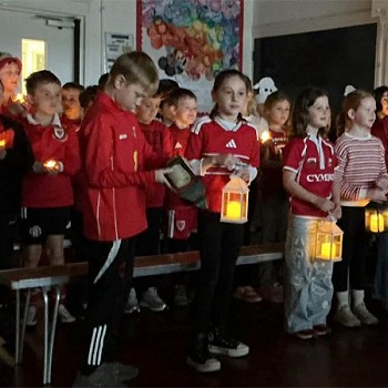 Plant yn gafael mewn canwyllau yn y tywyllwch fel rhan or gwasanaeth