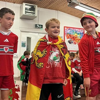 Tri plentyn yn gwisgo coch ac yn cymryd rhan yn y gwasanaeth